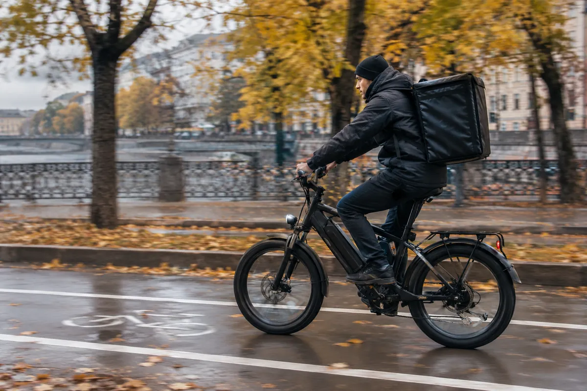 Велокурьер на электровелосипеде в городе
